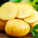 반으로 자른 노란 감자의 단면이 촉촉하게 빛나는 모습으로, 당뇨 환자도 섭취 가능한 감자의 식이섬유와 영양을 보여주는 이미지 A freshly cut yellow potato with moist texture, showing the fiber and nutrition suitable for diabetes management