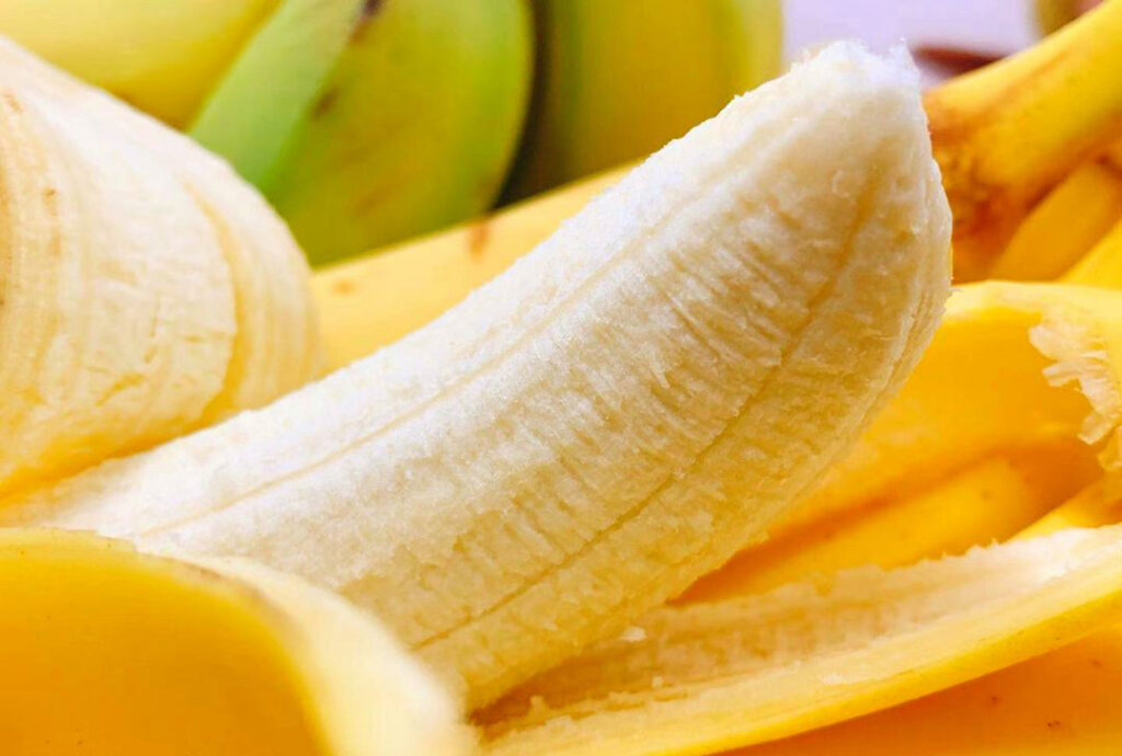 껍질을 벗긴 바나나의 근접 촬영으로, 부드럽고 달콤한 과육과 소화에 도움 되는 섬유질을 강조한 이미지 A close-up of a peeled banana highlighting its soft, sweet flesh and digestive fiber benefits